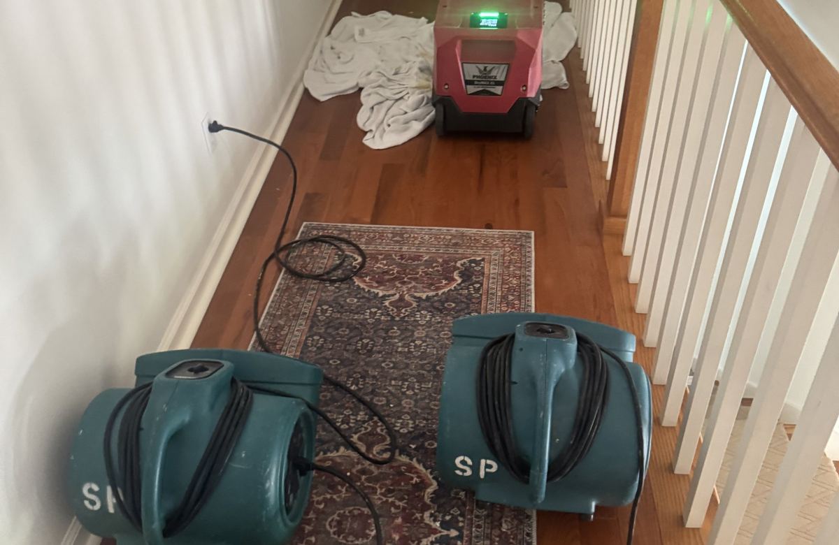 Upstairs hallway during drying: two air movers on the runner, dehumidifier at the end