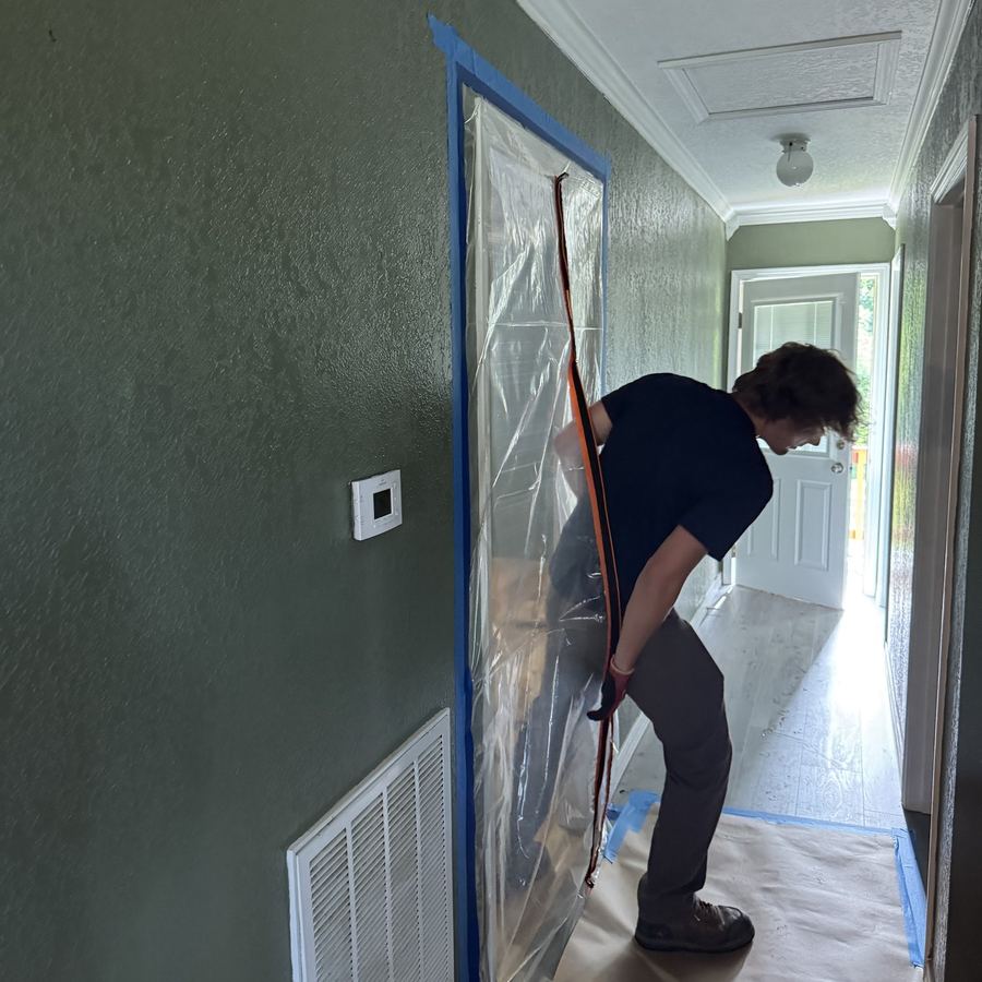 Crew member zipping a containment door shut in a hallway