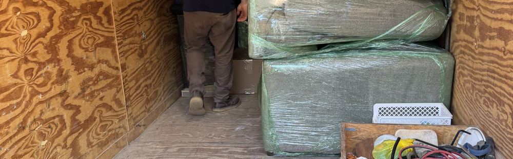 Crew member loading drying equipment into the enclosed Steam-Pro trailer